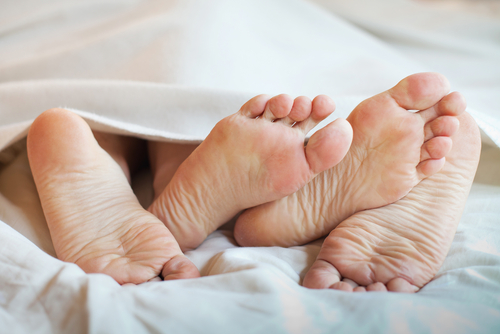 Feet Of Couple In Bed shockwave therapy