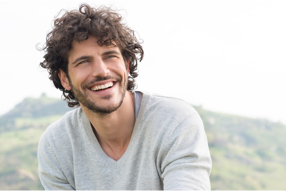 man smiling outdoors looking positive