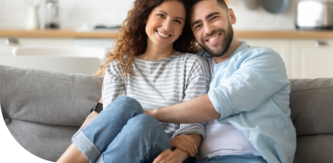 couple sitting on couch smiling